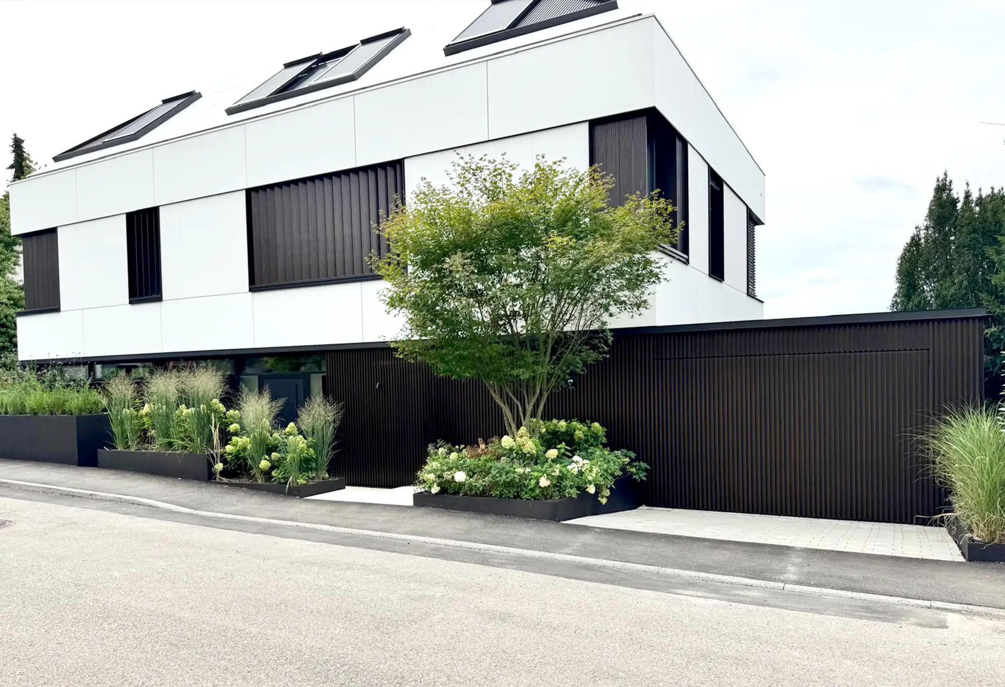 Lamellenfassade aus Metall an einem modernen Wohnhaus, Garagen- und Eingangsbereich verkleidet